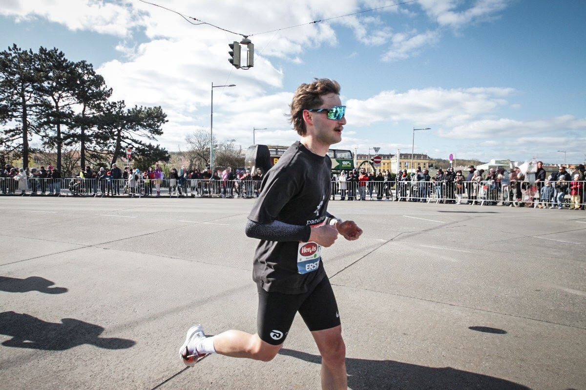 Runner celebrating after the Vienna City Half Marathon 2025 finish line.